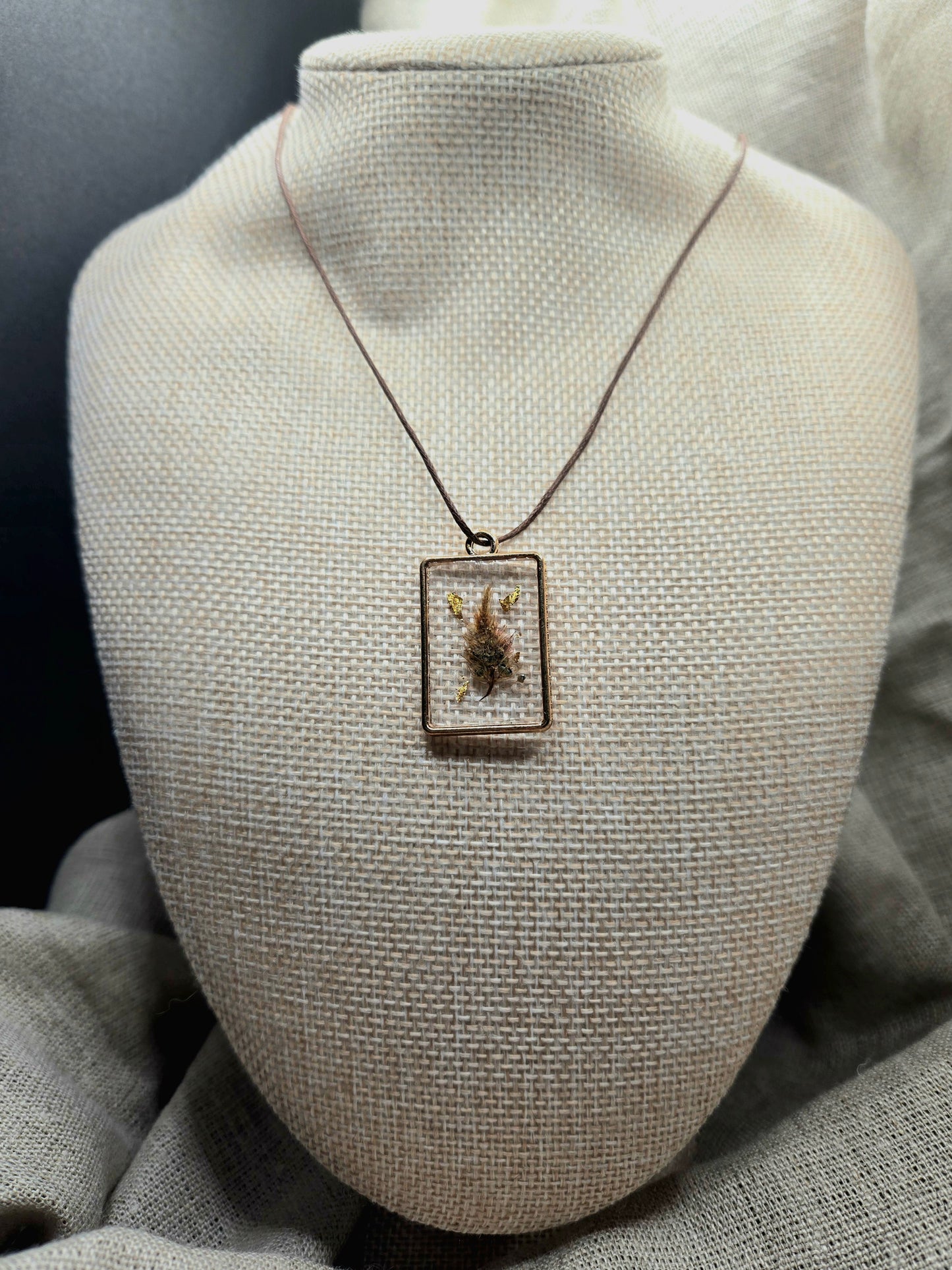 Square pendant with gold leaf.