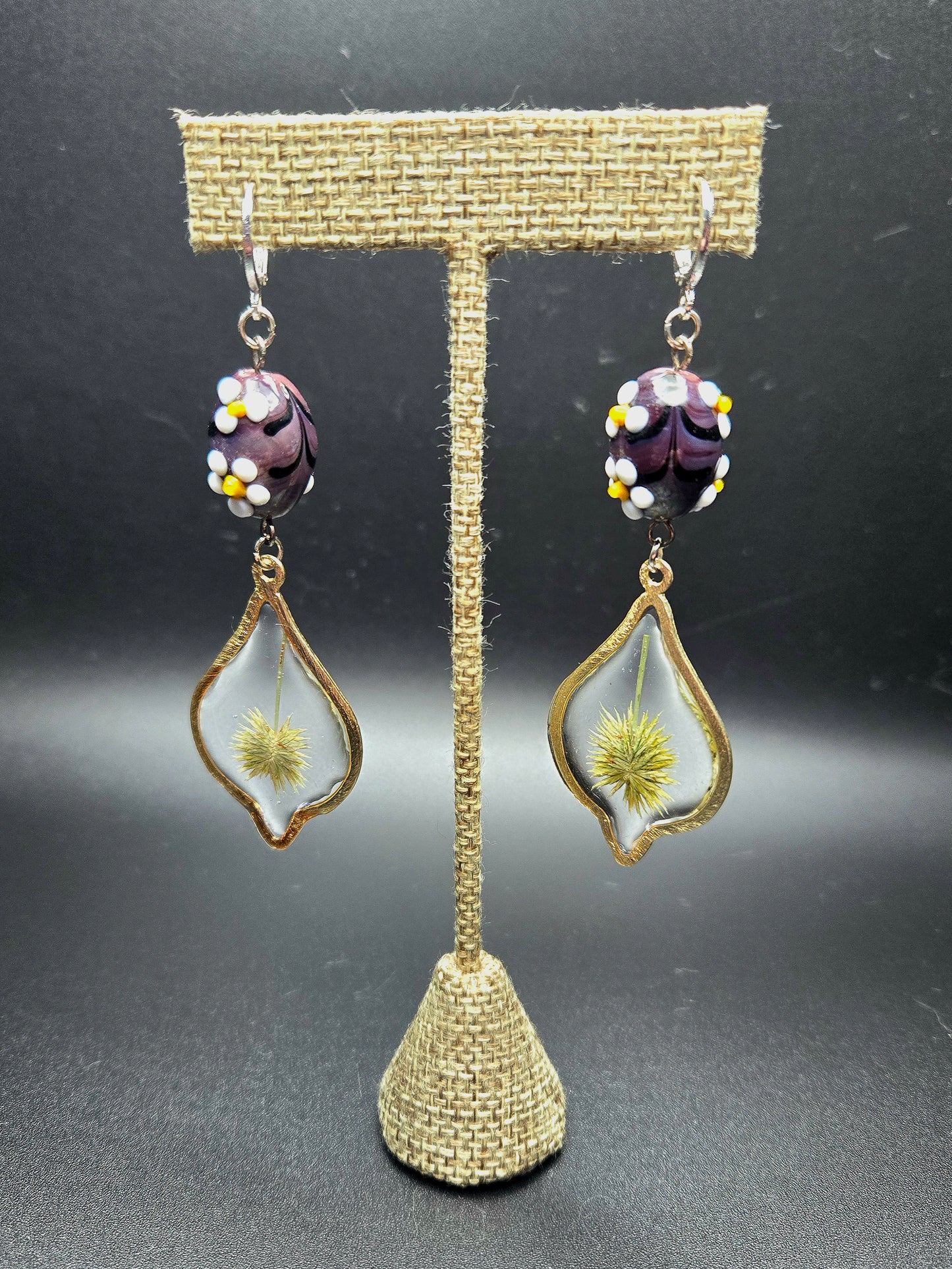 Silver colored dangle earrings with bright glass bead detail.