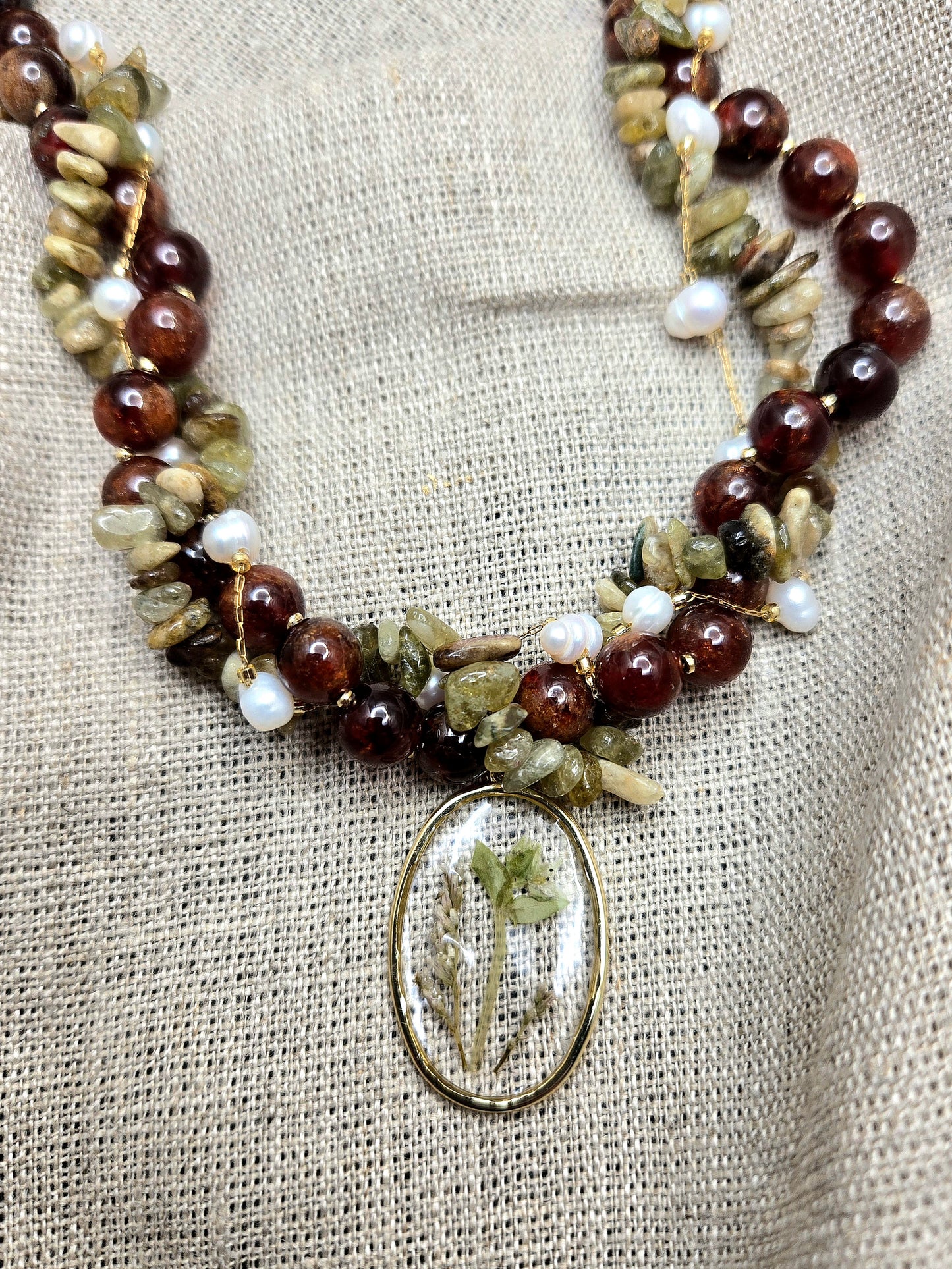 Red and green twisted necklace with floral pendant